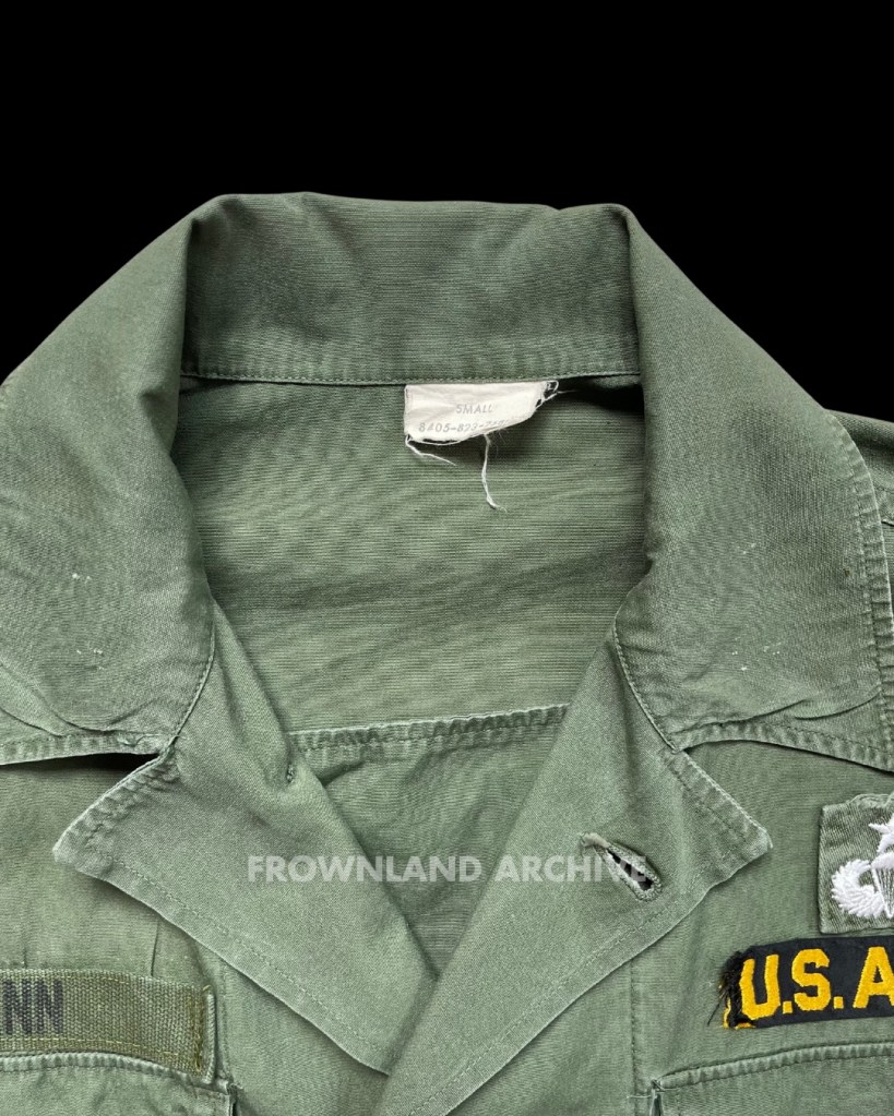 special warfare shirt belonged to Lt. Col. Juan W. Spann, 2 tours in Vietnam with 101st Airborne Divison. Slide no 3 is him when in Operation Somerset Plain (August 1968). In the early 1960s, Natick Laboratories began developing prototype jungle clothing uniforms for the Special Forces in Southeast Asia. One such example is the two-piece “Special Warfare” uniform. Made from 6oz nylon/cotton poplin, it was used until 1965. You can identify these uniforms by the extra gas-flap and adjustable sleeve gusset on the arms. If the tag’s text is still readable, it will say “SPECIAL.WARFARE”. My example has the contract number “CONT.NO.5186”. According to forum discussions, the term “Special Warfare” refers to conditions outside the normal temperature/climate expected for the US Army. This uniform was not a private purchase like FOTL (Fruit of the Loom) nor privately tailored like Maharajah; it was indeed issued to personnel before introducing the 1st pattern jungle jacket. The material is very thin, making these items rare, especially the trousers (information sourced from Shelby Stanton’s book and the USMF forum).