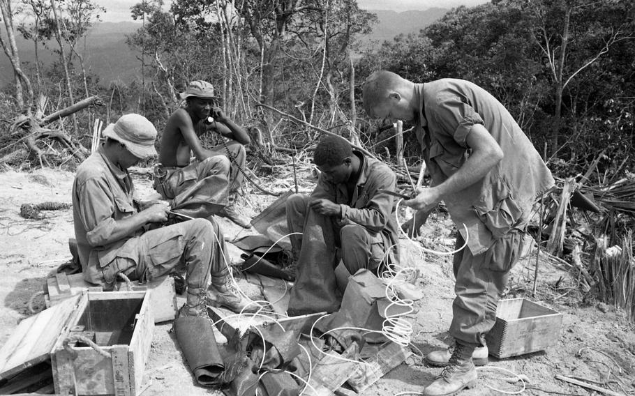 A Shau area, South Vietnam, Aug. 9, 1968: Engineers — taking part in Operation Somerset Plain, fix dynamite to blow up trees on top of a hill for landing zone.